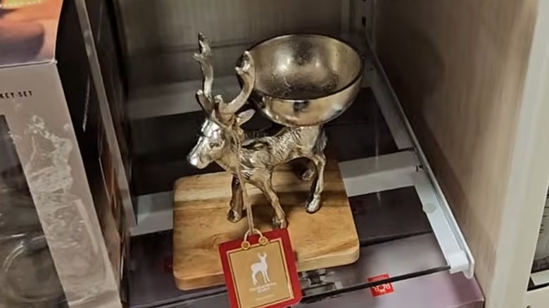 A gilded candy bowl mounted on the back of a gilded reindeer statue