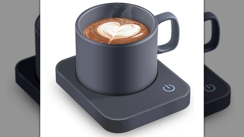A coffee mug sitting on a VOBAGA Mug Warmer on a white background