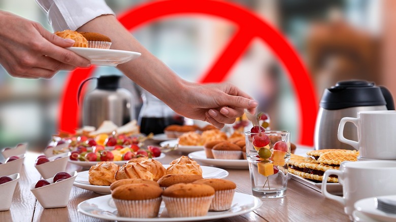 Person reaching for breakfast buffet food