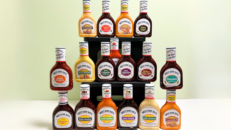 Seventeen bottles of Sweet Baby Ray's sauces arranged in three vertical rows