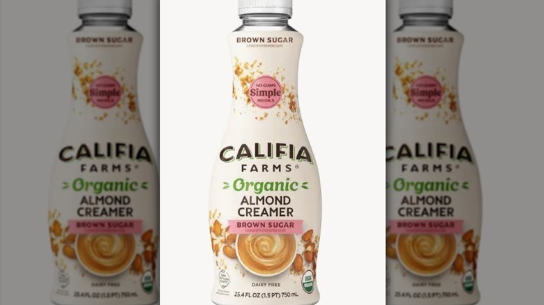 Califia Farms brown sugar almond creamer in a white bottle with green and pink accents on white background