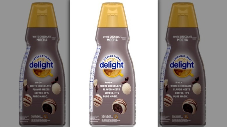 International Delight white chocolate mocha creamer in a taupe and gold bottle on white background
