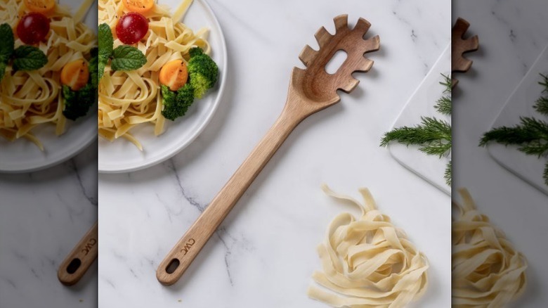 Wooden pasta spoon on counter next to pasta plate