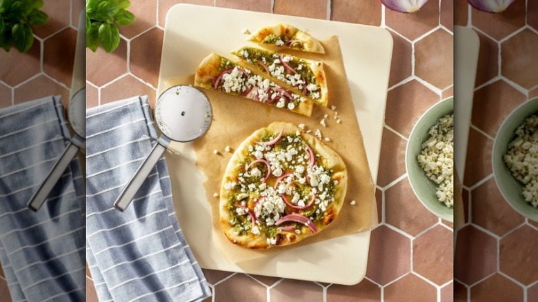 Figment stainless steel pizza cutter on cutting board with pizza