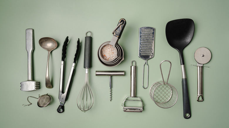 Various kitchen utensils on green background