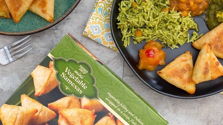 Veggie samosas on plate with green box nearby