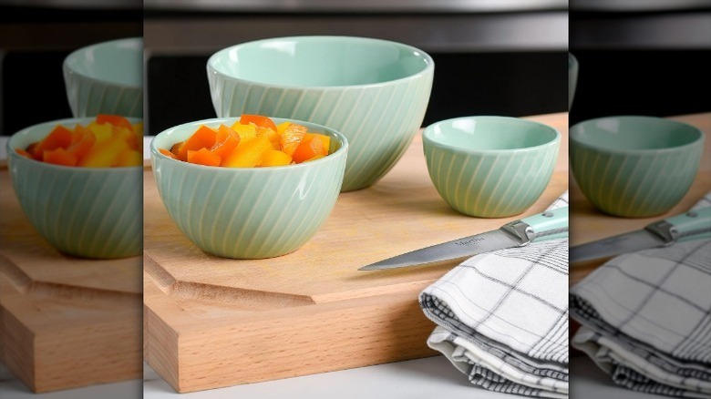 3-piece mixing bowl set on wood cutting board with fruit in one bowl