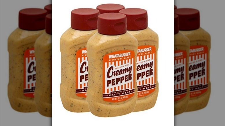 Whataburger creamy pepper sauce four pack with orange, white, and brown labels on white background
