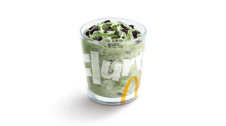 A green McFlurry with bits of Oreo in a clear glass