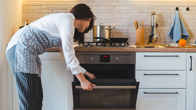 woman opening oven door
