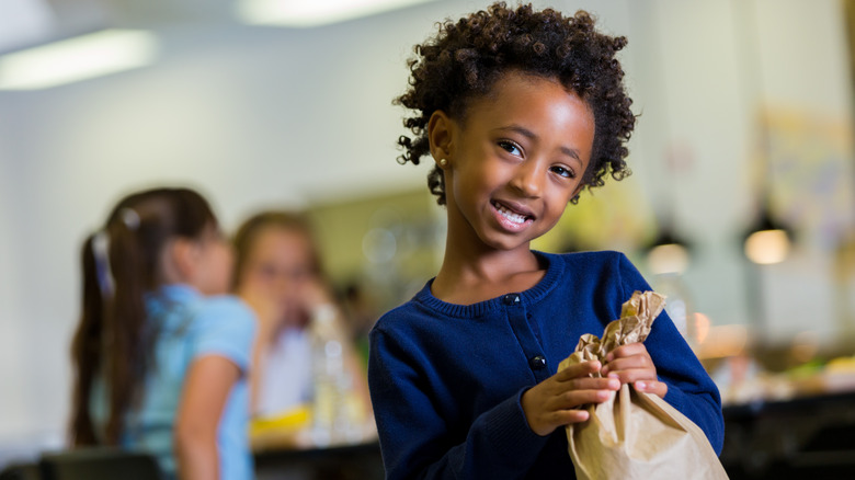 girl with paper bag lunch