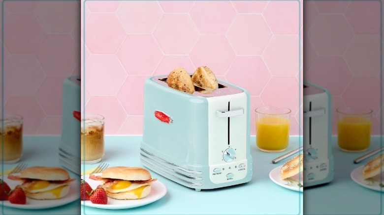 Toaster on blue counter with pink background and food