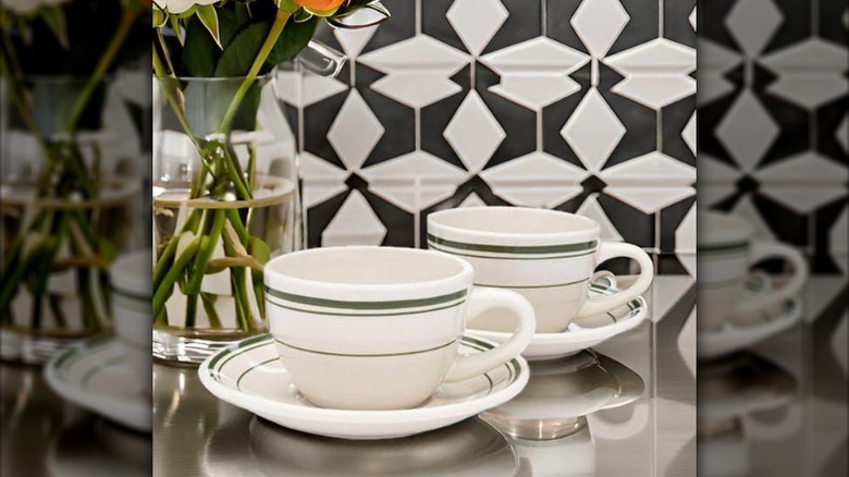 Diner mugs with saucers on table.