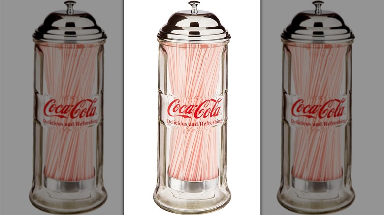 Coca-Cola straw dispenser against white background.