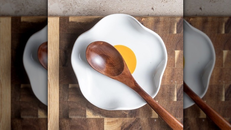 Wooden spoon resting on fried egg spatula holder