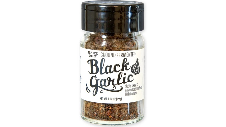 Shaker of Trader Joe's Ground Fermented Black Garlic against white background.