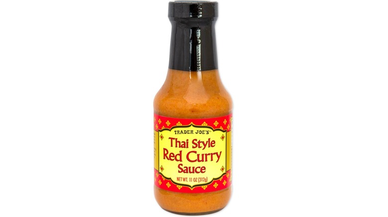 Bottle of Trader Joe's Thai Style Red Curry Sauce against white background.