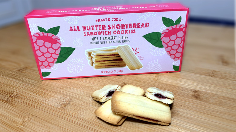 Raspberry shortbread cookies on cutting board next to product box