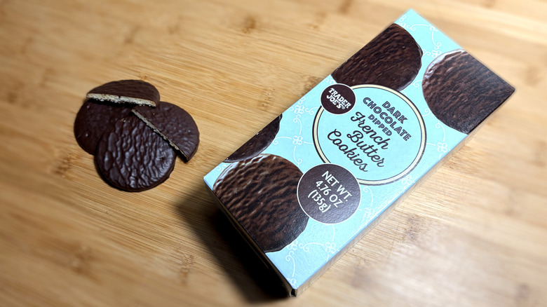Chocolate-covered butter cookies on cutting board next to product box