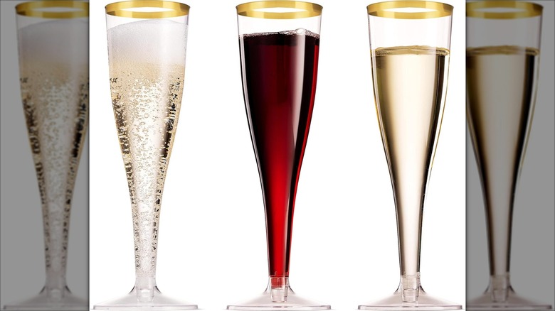 Munfix Gold Rimmed Plastic Champagne Flutes filled with liquid