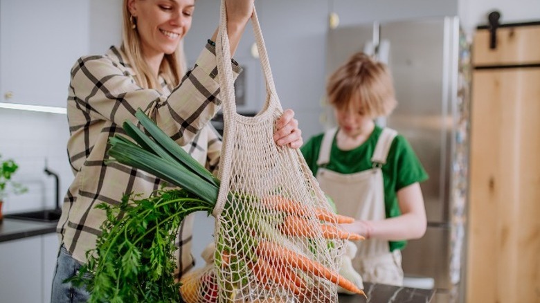 woman holding mesh reusable bag