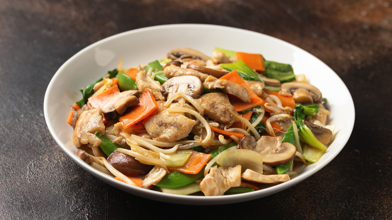 Chicken and vegetable chop suey in a white bowl