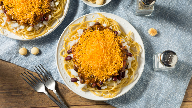 Cincinnati chili with cheese and onions served on a white plate