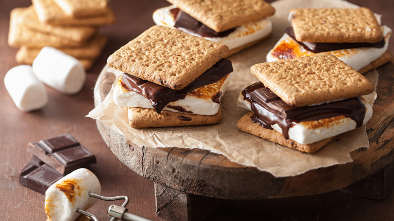 A plate of smores, with a toasted marshmallow and some chocolate