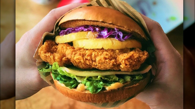 Hands holding buttermilk crispy chicken