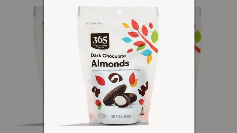 A bag of 365 by Whole Foods Market Dark Chocolate Covered Almonds on a white background