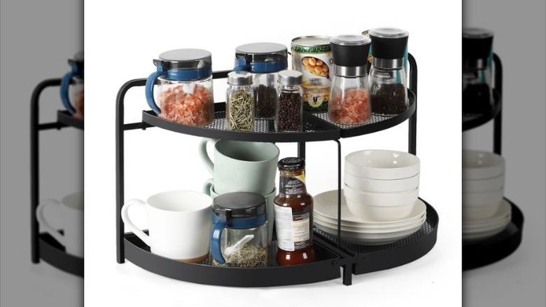 Dishes and spices on rotating black metal tray against white background.