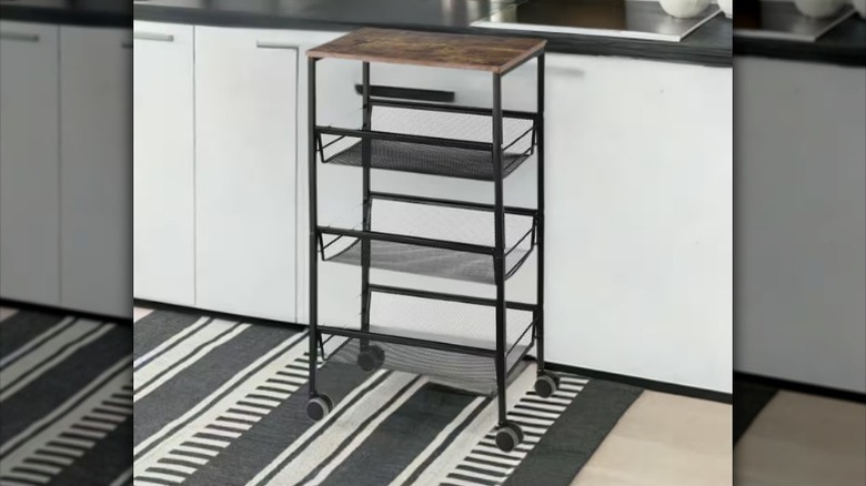 Three-tiered cart next to kitchen counter.