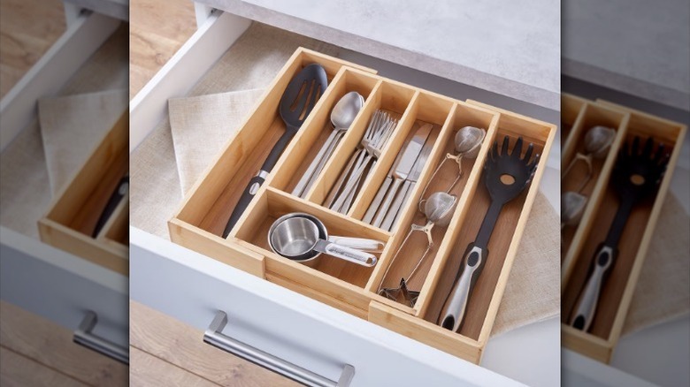 Bamboo tray with silverware and cooking utensils in kitchen drawer.