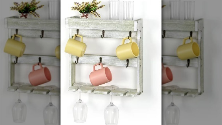 Three mugs hanging on wall-mounted mug shelf.