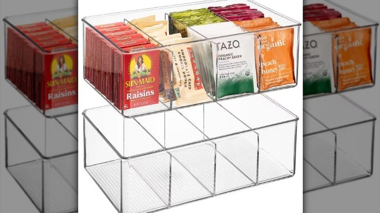 Snacks and tea bags in clear storage bin organizer against white background.
