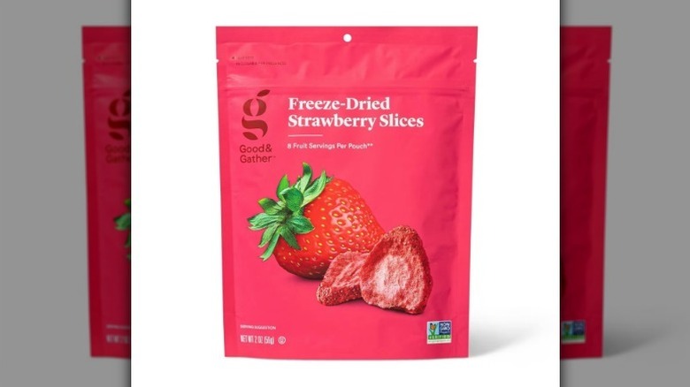 Freeze dried strawberries in a pink bag on white background