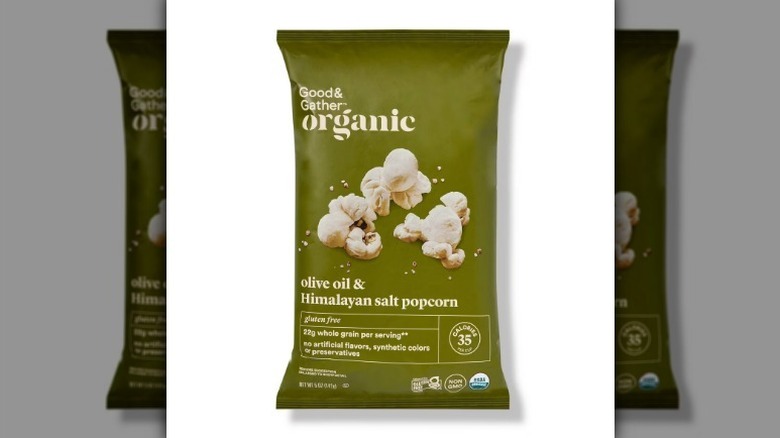 Olive oil popcorn in an olive green bag on white background