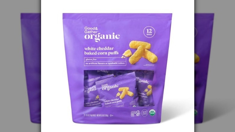 White cheddar corn puffs in purple bag on white background