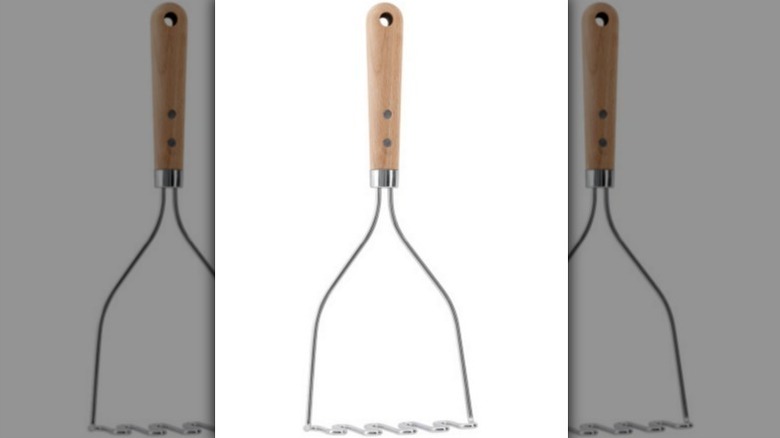 Potato masher with wooden handle on white background