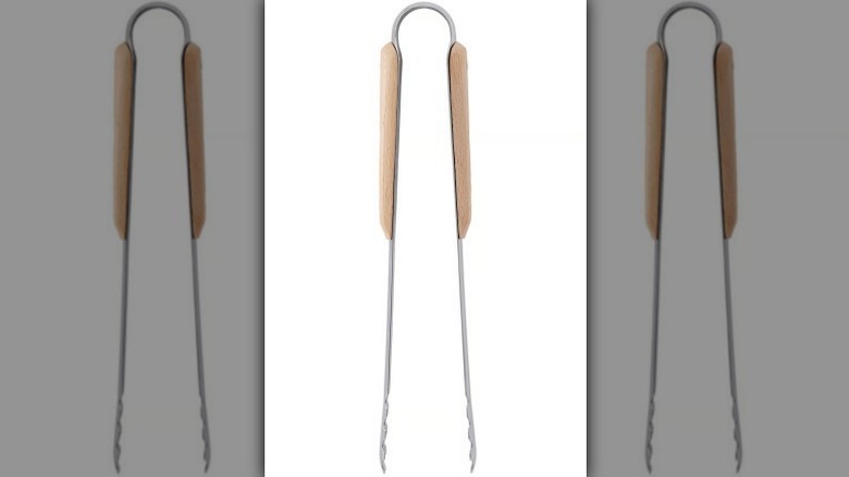 Stainless steel tongs with beige handles on white background