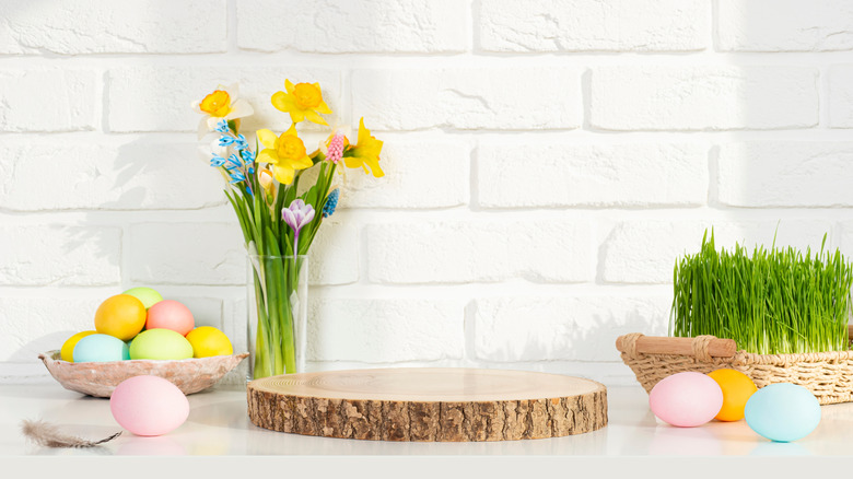 White counter with white brick backsplash decorated with spring item like flowers and eggs
