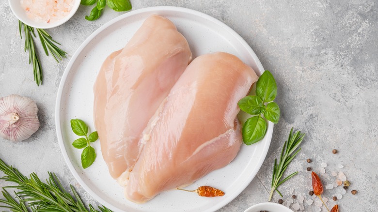 Raw chicken breasts on a plate