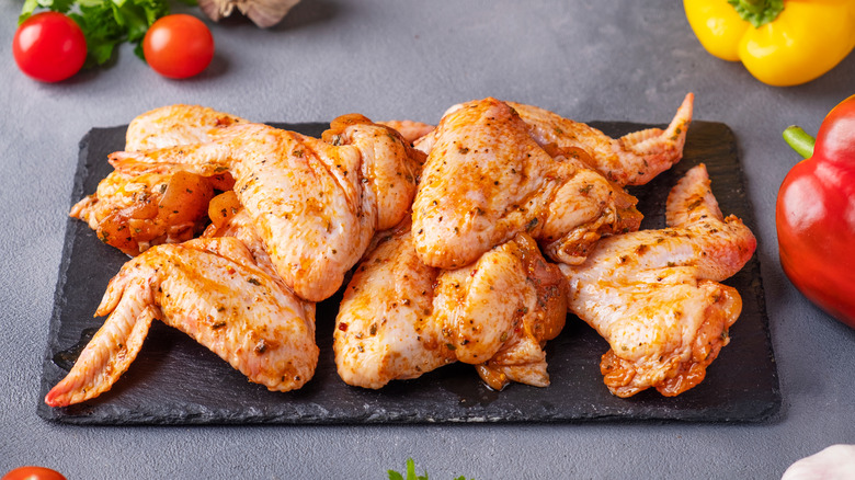 plate of raw chicken wings in marinade