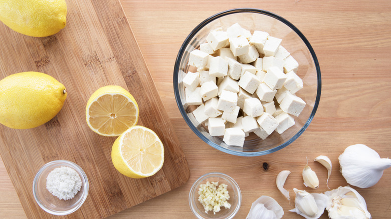 Bowl of cubed fresh tofu with lemons and garlic for marinade