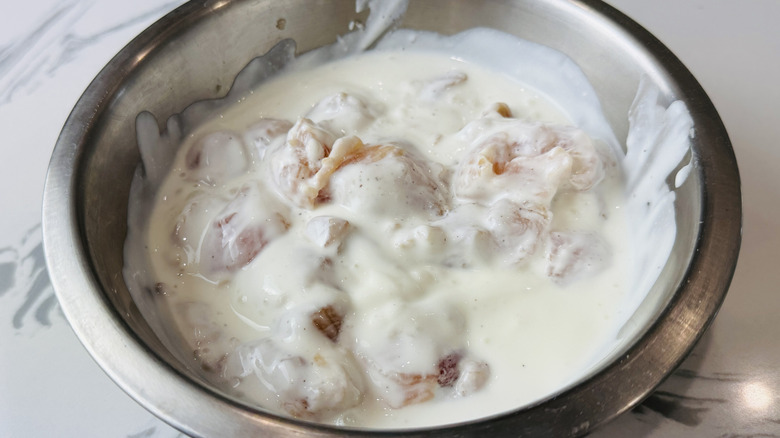 Chicken in bowl coated with buttermilk