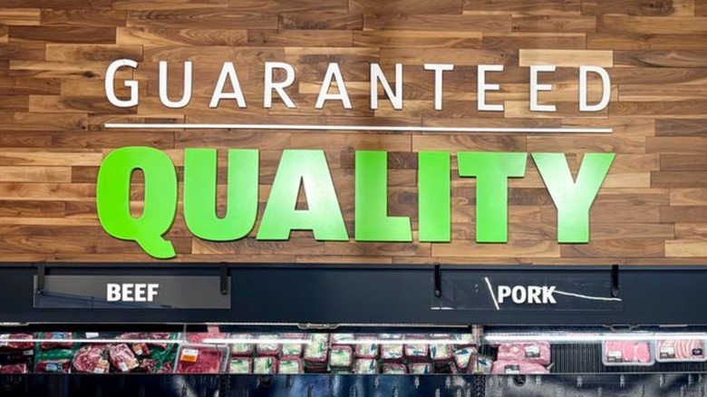 A sign inside Aldi that says "Guaranteed Quality" in green text on a brown wood background