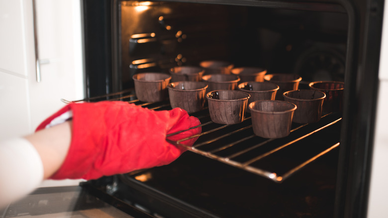 gloved hand grabbing oven rack
