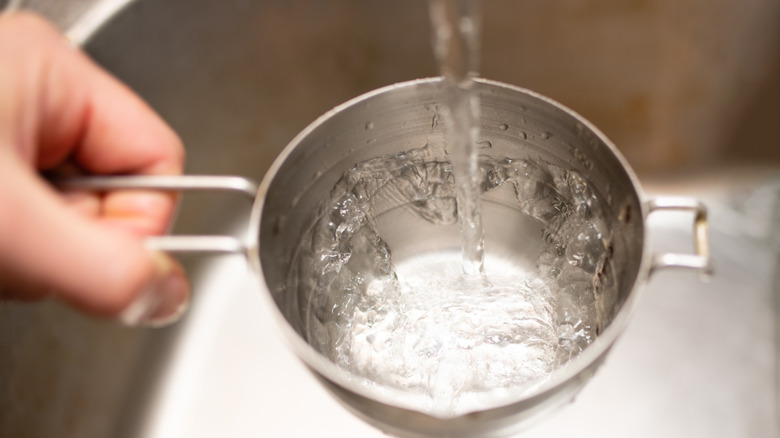 filling measuring cup with water