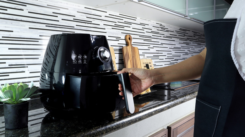 person opening air fryer