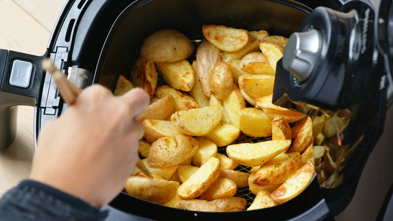 stirring potatoes in air fryer